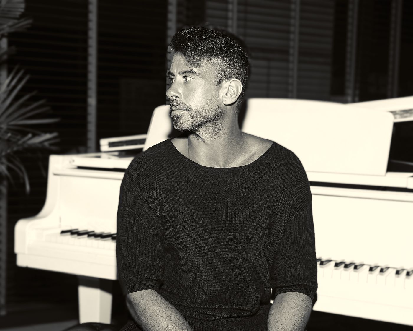 ARACIL photographed beside a white grand piano, horizontal press photo